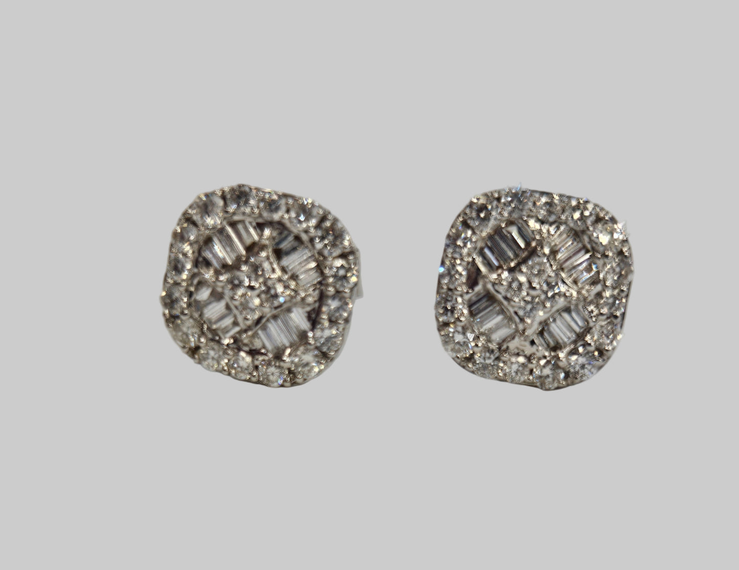 Pair of silver earrings with gemstones on a light gray background