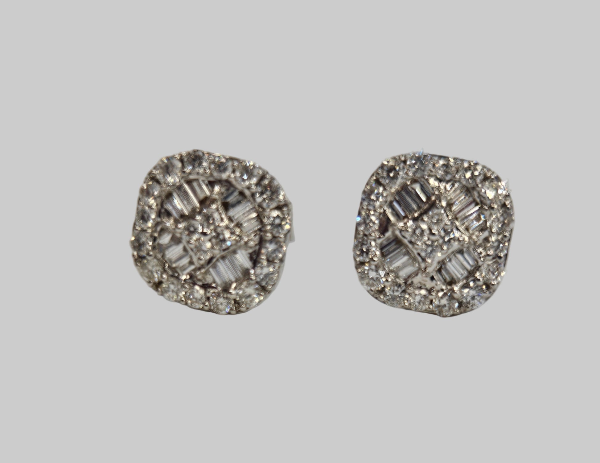 Pair of silver earrings with gemstones on a light gray background